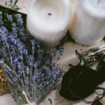 white pillar candle beside silver and black hair brush