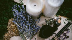 white pillar candle beside silver and black hair brush